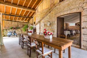 una grande sala da pranzo con tavolo e sedie in legno di Agriturismo Il Salice a Tizzano Val Parma