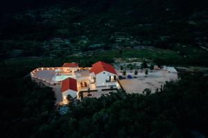 a large white house with red roofs on a hill at Vila Agape with a pool, football and tennis court in Lovreć