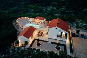 an aerial view of a house with a red roof at Vila Agape with a pool, football and tennis court in Lovreć