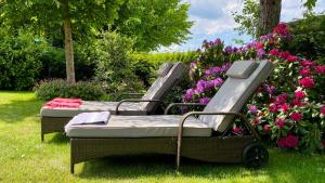 two beds sitting in the grass with flowers at 4-Star Holiday House Rösslewiese in Hinterzarten