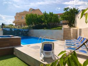 a backyard with a swimming pool and two chairs at Luxury Villa with Private Pool and Jacuzzi in Gnojnice