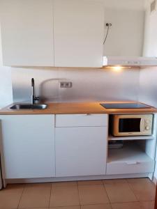 een witte keuken met een wastafel en een magnetron bij FELIX HOUSE sea views in Costa de Antigua