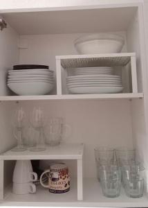 a white shelf with plates and bowls and dishes at FELIX HOUSE sea views in Costa de Antigua
