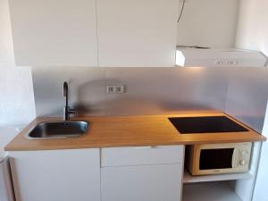 a small kitchen with a sink and a microwave at FELIX HOUSE sea views in Costa de Antigua