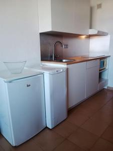 uma cozinha com armários brancos, um lavatório e um frigorífico em FELIX HOUSE sea views em Costa de Antigua