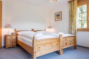 een slaapkamer met een houten bed en een raam bij Apartment Hori - GRIWA RENT AG in Grindelwald
