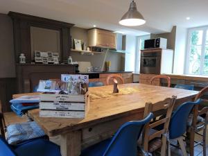 een keuken met een houten tafel en blauwe stoelen bij Le domaine des Ecureuils in Vassy