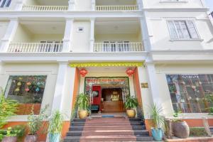 Casa blanca con una escalera que conduce a la puerta principal en T&T Resort And Spa, en Phu Quoc