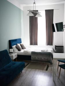sypialnia z łóżkiem i niebieską kanapą w obiekcie Old Town Studio w mieście Przemyśl