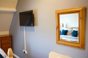 a bedroom with a mirror and a bed at The Annex Brook House Farm, Abbey views, Yorkshire Coast Holiday Lets in Whitby
