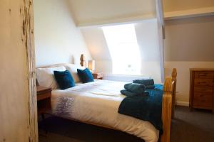 a bedroom with a bed with blue pillows and a window at The Annex Brook House Farm, Abbey views, Yorkshire Coast Holiday Lets in Whitby