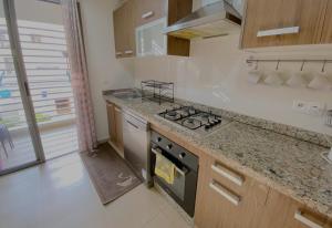 a kitchen with a stove and a counter top at Luxury résidence Taj Nouaceur in Nouaseur