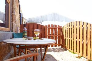 a wooden table with a bottle of wine and a glass at The Annex Brook House Farm, Abbey views, Yorkshire Coast Holiday Lets in Whitby