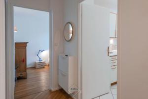 a white refrigerator in a room with a mirror at Palissy apartment near Disneyland in Bussy-Saint-Georges