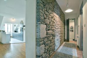 uma parede de pedra no corredor de uma casa em Le Sainte Catherine - Appt centre-historique em Dinan