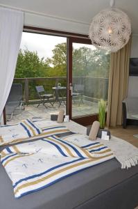 a large bed in a bedroom with a balcony at Hotel Neptuns Ankerplatz in Cuxhaven