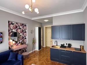 a kitchen with blue cabinets and a living room at Premium Apartment in Spiski Palace in Krakow