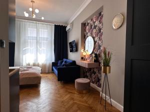 a living room with a blue couch and a mirror at Premium Apartment in Spiski Palace in Krakow