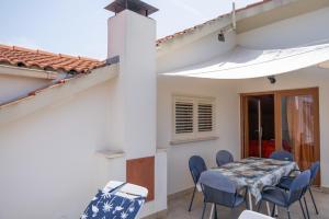 a dining room with a table and blue chairs at Protić Apartments in Vela Luka