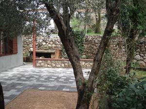 un mur en pierre avec un banc dans une cour dans l'établissement Apartments Mia, à Starigrad-Paklenica