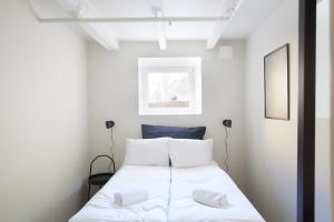 - une chambre dotée d'un lit avec des draps blancs dans l'établissement Grünerløkka shared Apartment Rooms, à Oslo