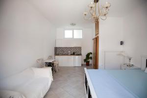 a white room with a bed and a kitchen at Hara's Studio in Perdika