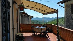 a patio with a table and chairs on a balcony at Il Nido Magico Incanto e magia nel borgo antico in Calice al Cornoviglio