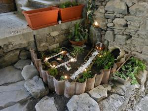 un giardino con piante e luci in un muro di pietra di Il Nido Magico Incanto e magia nel borgo antico a Calice al Cornoviglio