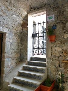 eine Treppe, die zu einer Tür in einem Steingebäude führt in der Unterkunft Il Nido Magico Incanto e magia nel borgo antico in Calice al Cornoviglio