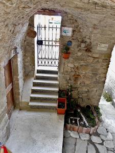 a stairway with a door and a stone wall at Il Nido Magico Incanto e magia nel borgo antico in Calice al Cornoviglio