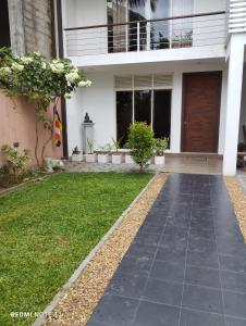 a house with a walkway in front of a yard at New White House in Colombo