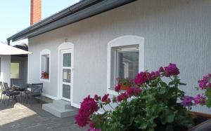 a house with purple flowers on the side of it at Apartment & Rooms Majetic-Draskovic in Bizovac
