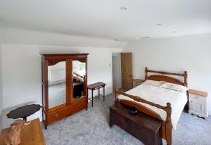 a bedroom with a bed and a dresser and a mirror at Abbeville in Two Dales