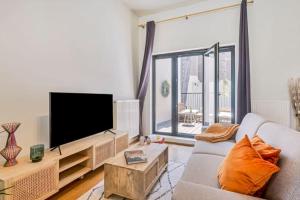 uma sala de estar com um sofá e uma televisão de ecrã plano em Wonderful apartment in the center of Antwerp em Antuérpia