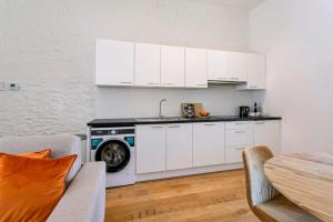 uma cozinha com armários brancos e uma máquina de lavar roupa em Wonderful apartment in the center of Antwerp em Antuérpia