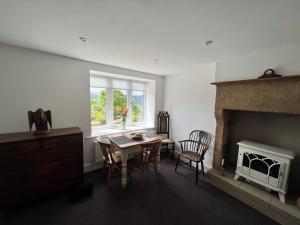 a living room with a table and a fireplace at Abbeville in Two Dales