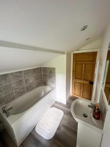 a bathroom with a bath tub and a sink at Abbeville in Two Dales