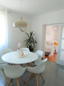 un comedor blanco con una mesa y sillas blancas en Bošana Beach Apartment Biograd, en Biograd na Moru