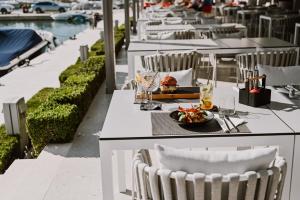 un tavolo con un piatto di cibo su un tavolo con sedie di Hotel Stomorin-Marina Hramina a Murter