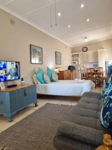 1 dormitorio con 1 cama grande y sala de estar en Eight Palms, en Port Edward