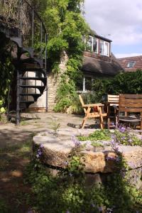 un jardin avec une table en bois et un banc dans l'établissement Sandford Meadow Guest House, à Oxford