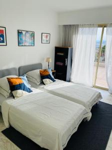 dwa łóżka siedzące obok siebie w sypialni w obiekcie Panoramic sea view penthouse with jacuzzi and 450 sqm terrace w mieście Antibes