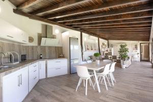 cocina con armarios blancos, mesa y sillas en Moderno loft recien reformado en Santa Cruz de Tenerife, en La Monja