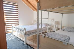 a bedroom with two bunk beds and a balcony at Forest Dream Lake House in Jajce