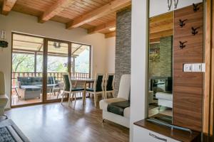 a dining room and living room with a table and chairs at Forest Dream Lake House in Jajce