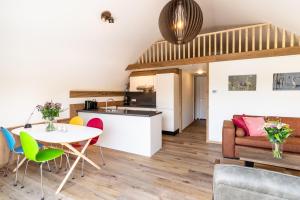 een keuken en een woonkamer met een tafel en stoelen bij 't Landgoed Baars in Baars