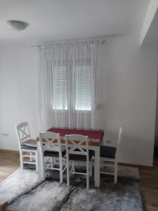 een eetkamer met een tafel en stoelen en een raam bij Ivana apartman in Vrnjačka Banja