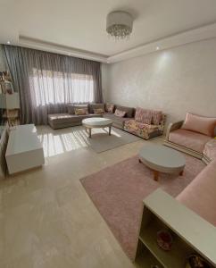 a living room with a couch and a table at Luxury résidence Taj Nouaceur in Nouaseur