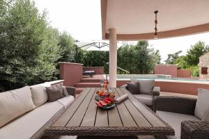 a patio with a wooden table and couches at Pool apartment with traditional Dalmatian Konoba in Nin