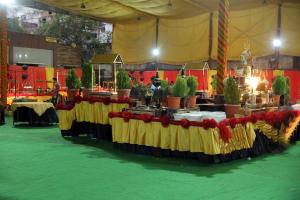印多爾的住宿－Hotel Shri Raam Krishna Baag Indore，帐篷里一张桌子上放着盆栽植物